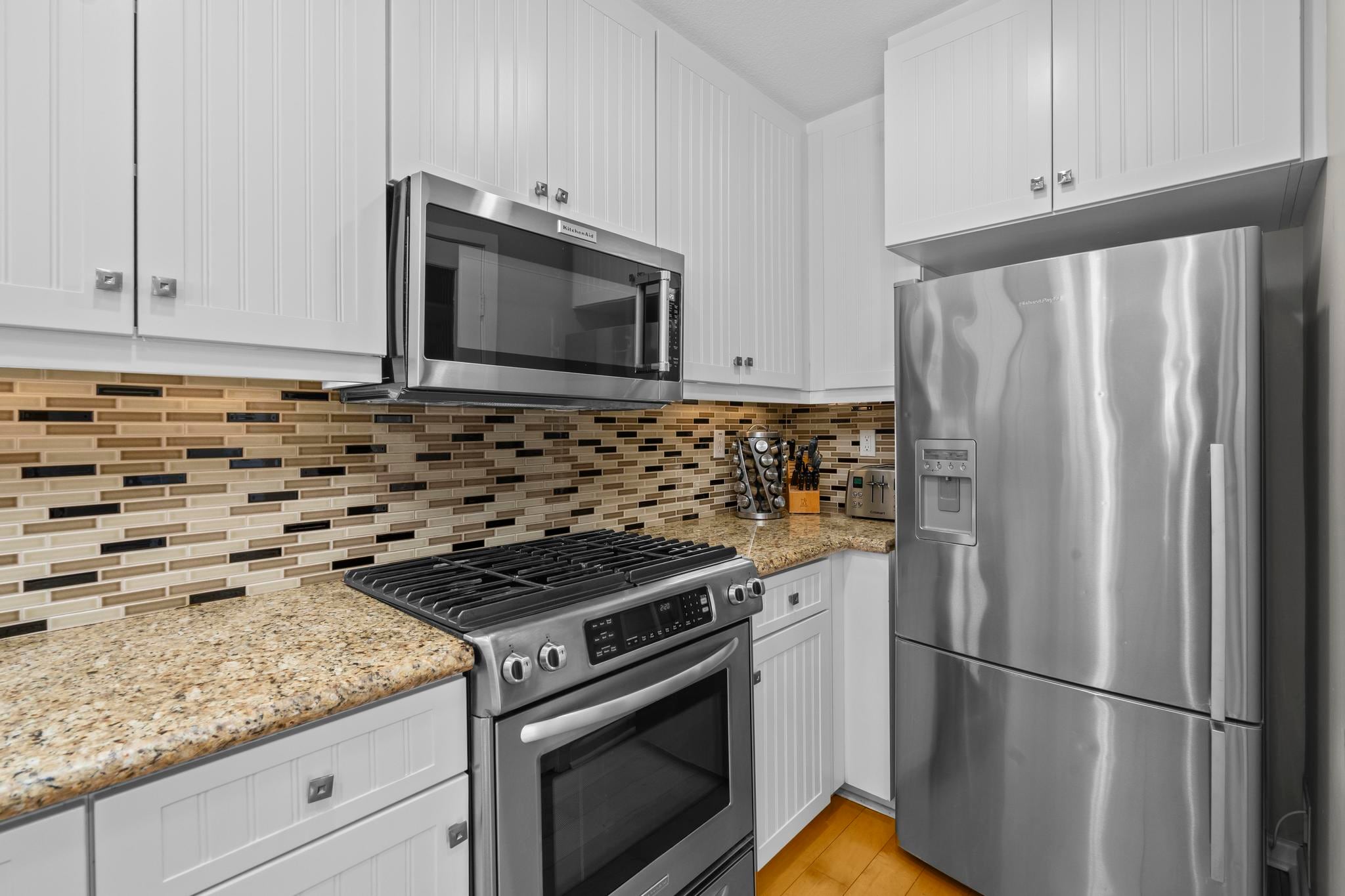 The kitchen at Belmont Beach House with stainless appliances and a tile backsplash