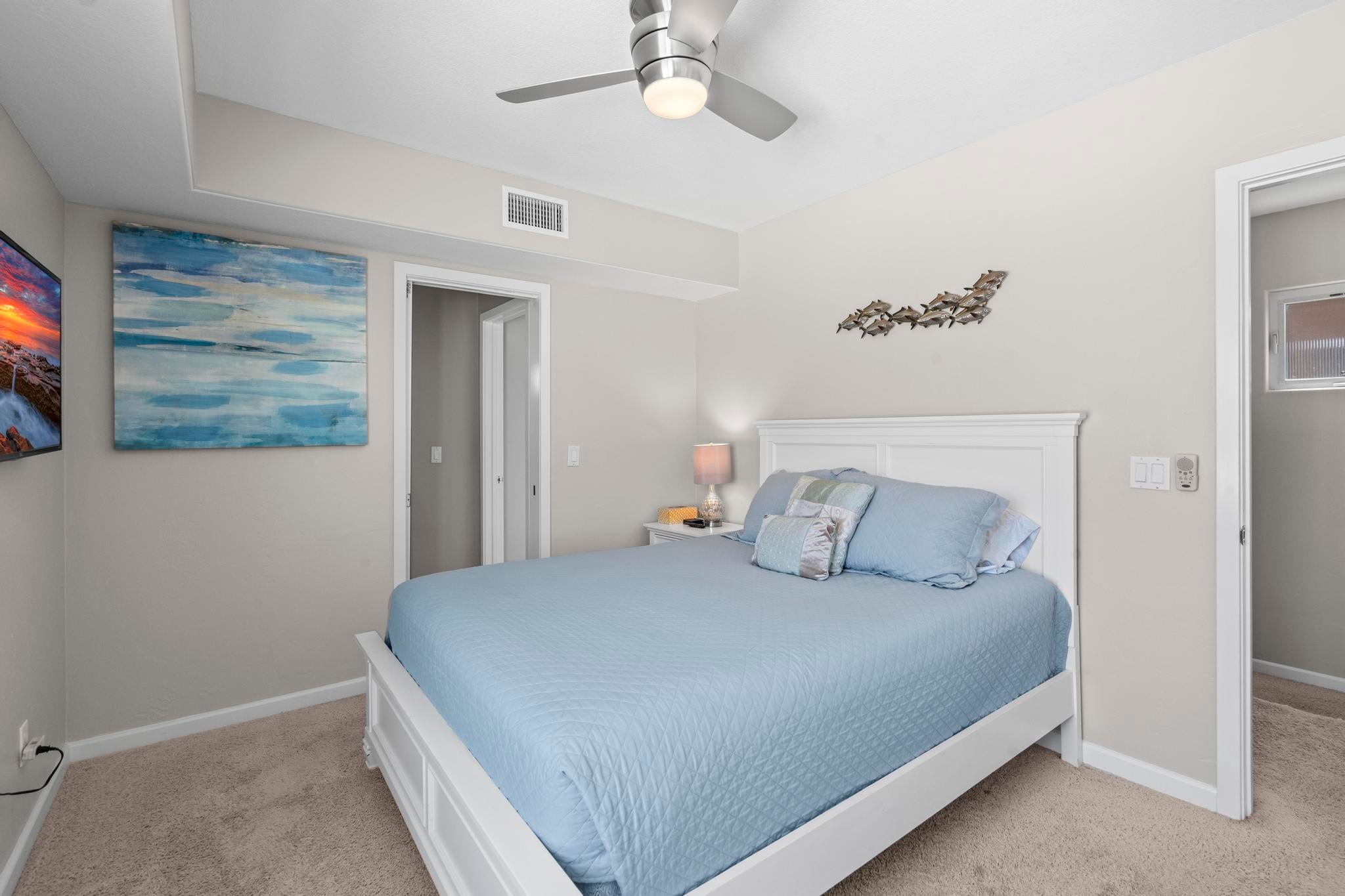 A second bedroom at Belmont Beach House with coastal artwork