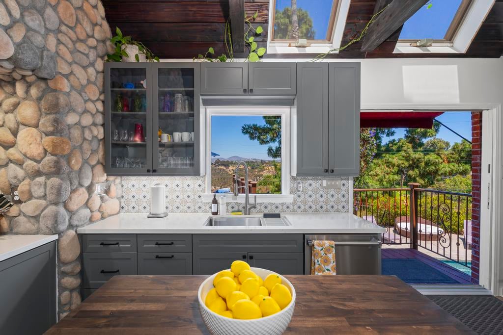 The kitchen window at Kensington Canyon opening to the canyon, with a bowl of lemons on the butcher block