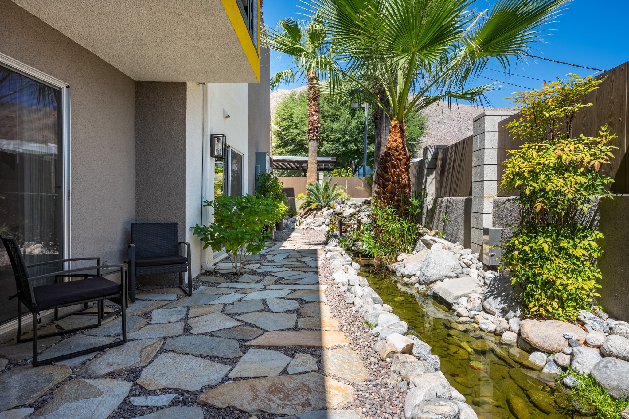 Back patio of Unit 104 after, screened and softened by mature planting