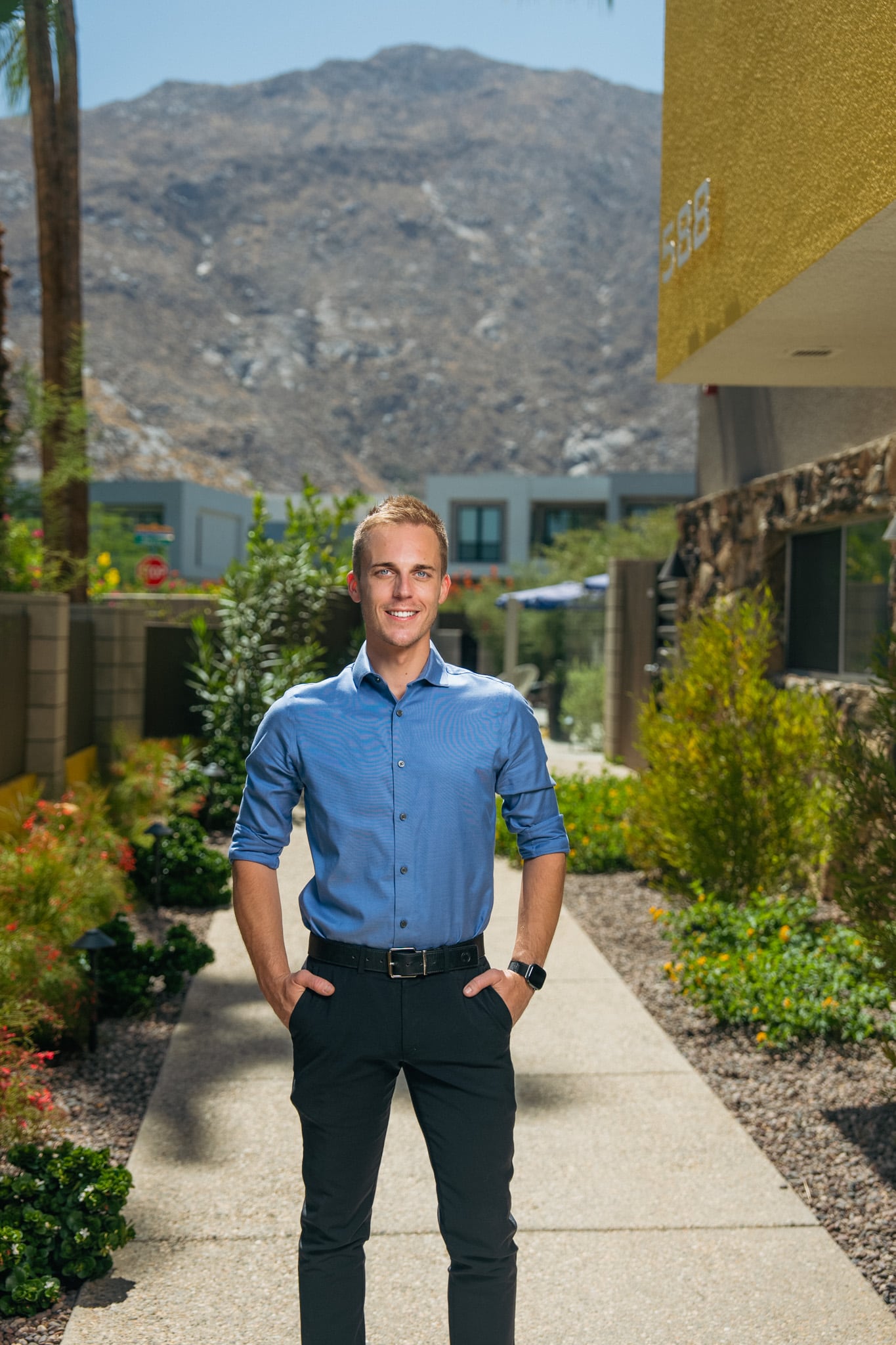 David Weis standing on the front walkway at Querencia Palms in Palm Springs, with the San Jacinto Mountains behind him