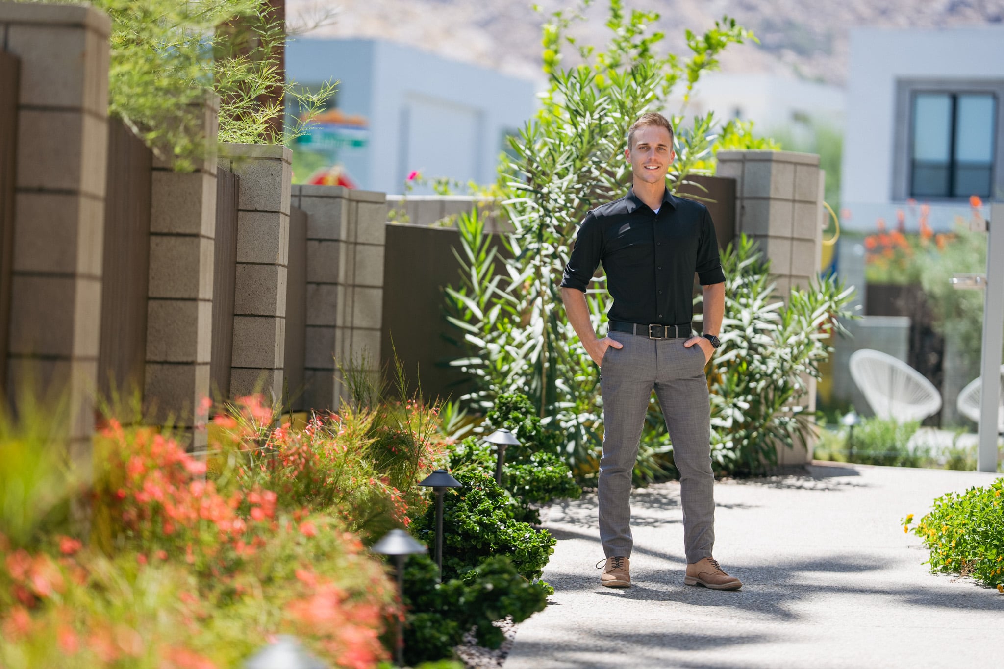 David Weis standing among the mature plantings along the Querencia Palms front walkway